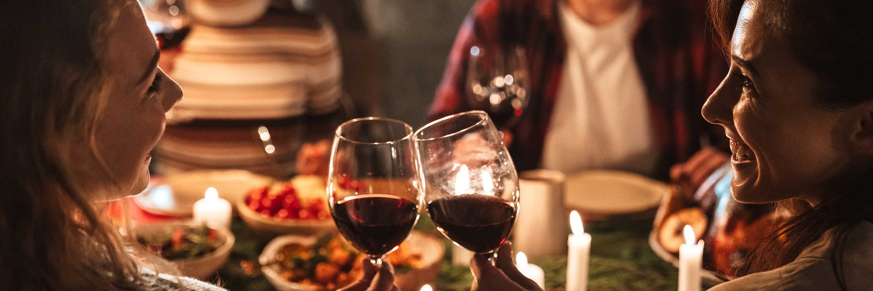 Photo of two women toasting at a dinner party